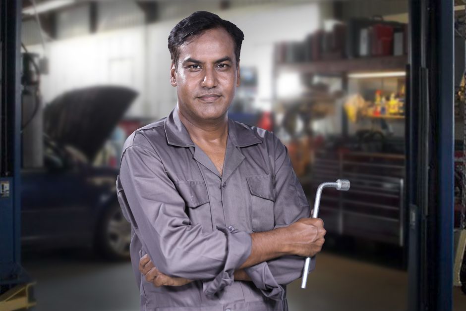Friendly auto service professional standing in a garage