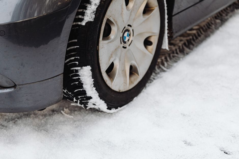 Technician checking tire tread depth and alignment
